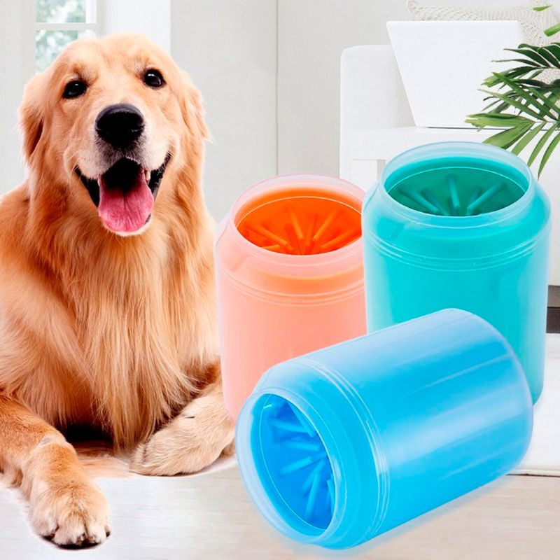 Golden retriever lying beside coral, teal and blue paw cleaner cups