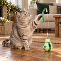 AI illustration: Mabel bats the green tassel on the Interactive Cat Tumbler Toy at Nosey Farm.